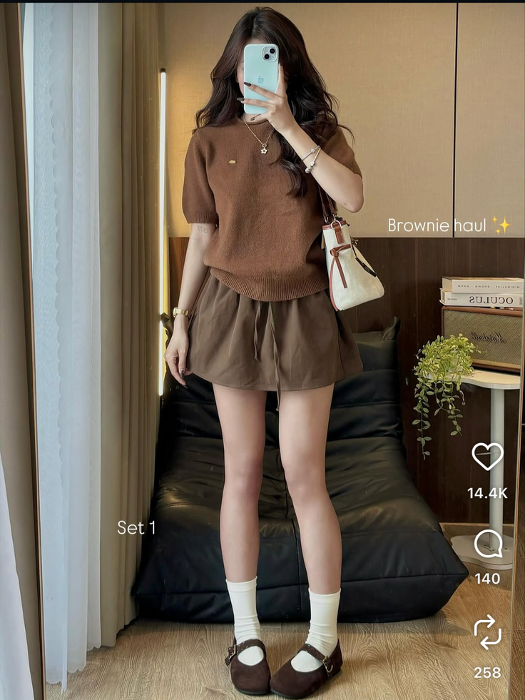 Woman in a brown top and shorts with mary jane shoes and white socks