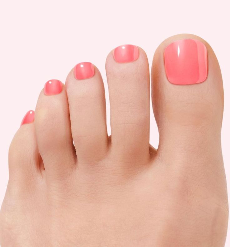 Close up of a foot with pink nail polish on a light background