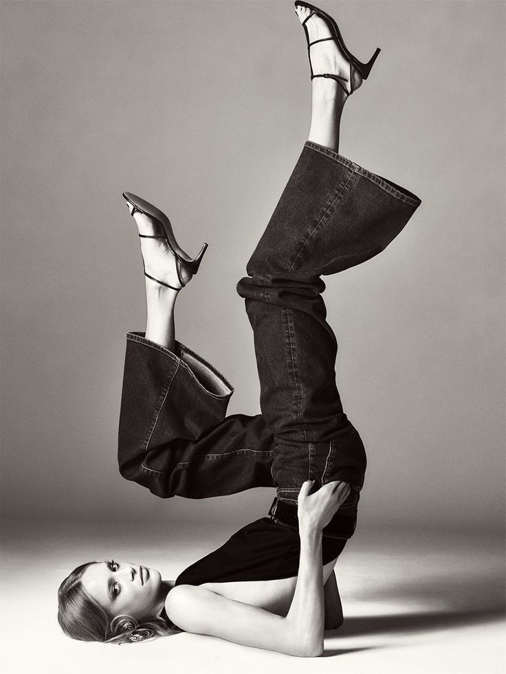 Woman in jeans and high heels in a dynamic pose on a studio floor