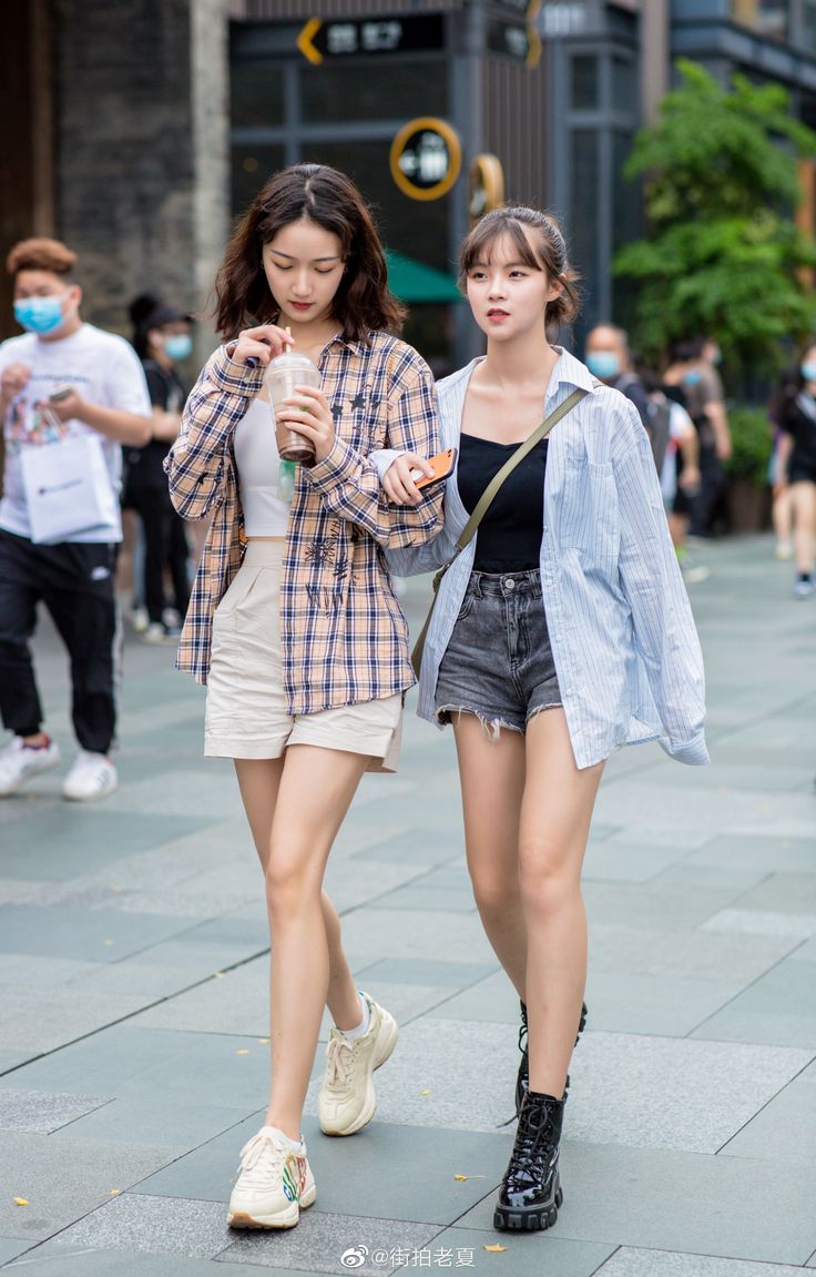 Two young women walking on a city street during the day