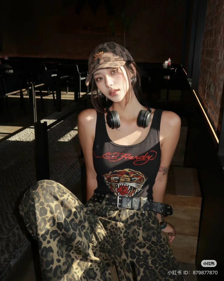 Woman in leopard print clothing and a tank top with headphones around her neck
