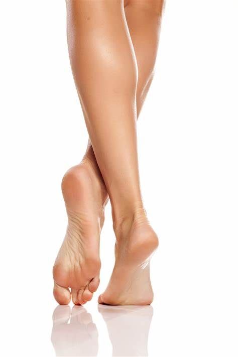 Bare legs and feet crossed, standing on tiptoes with a reflection below