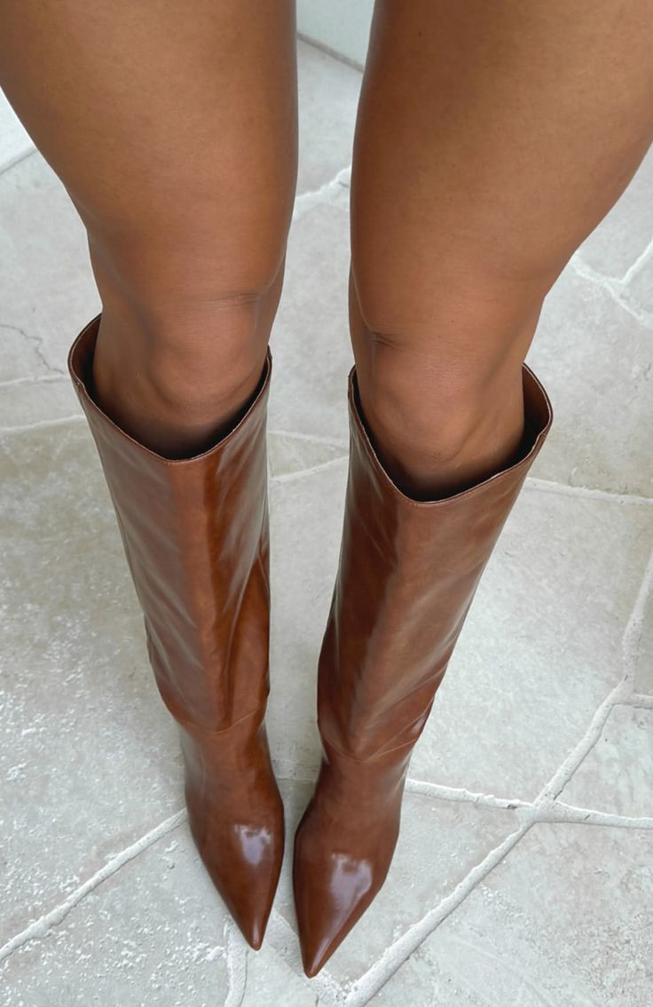 Person wearing brown knee-high boots with exposed skin above the boots