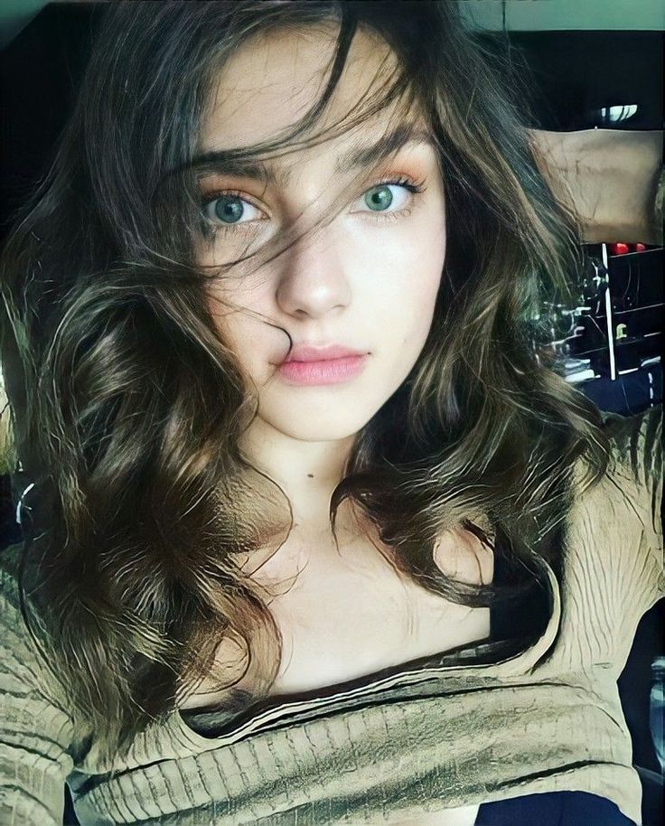 Woman with long wavy hair and green eyes looking directly at the camera