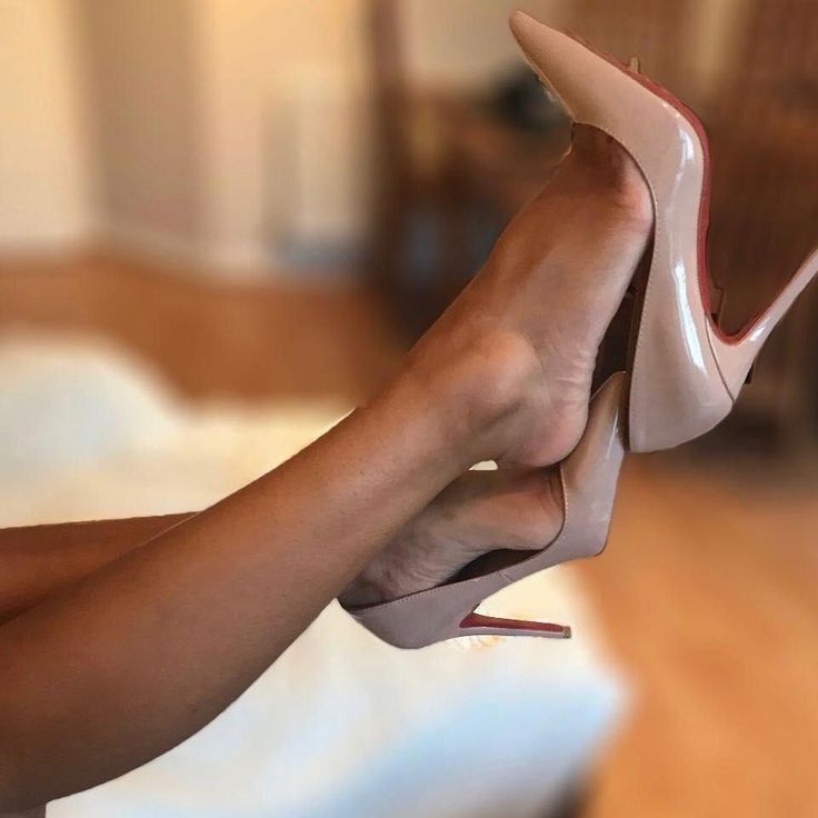 Woman's legs and feet in nude high heels with red soles