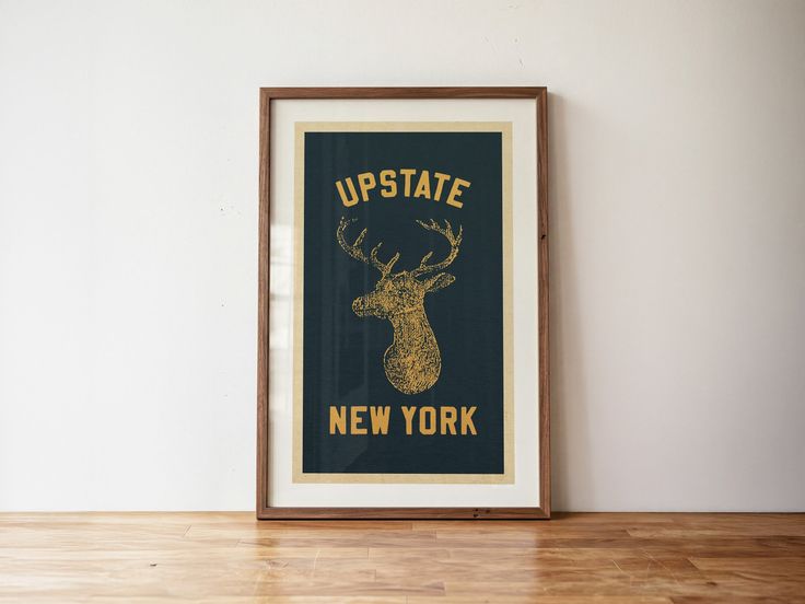 A framed poster with a deer head illustration and 'Upstate New York' text