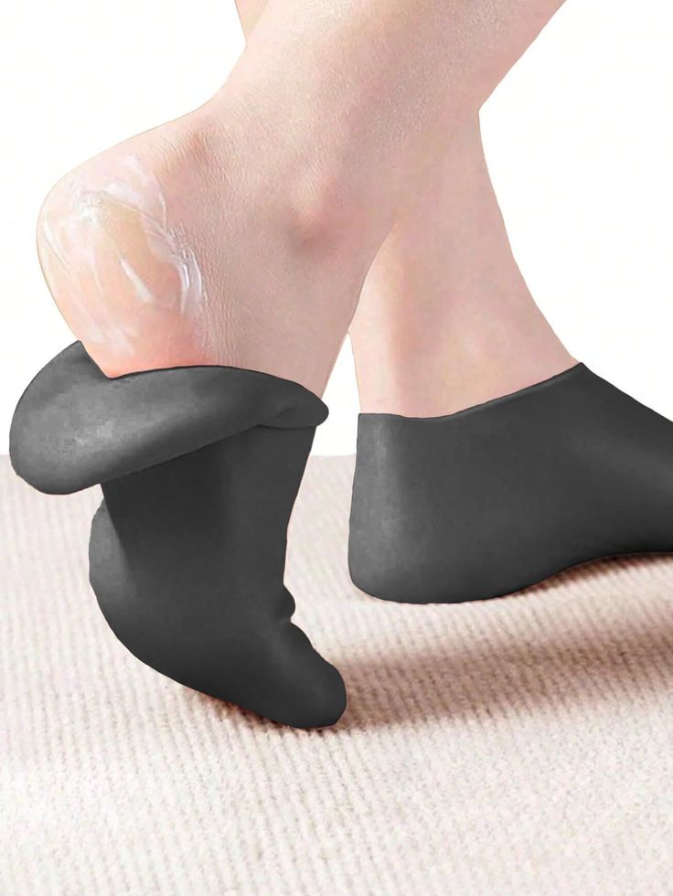Feet with cream on the heel and dark socks on a white background