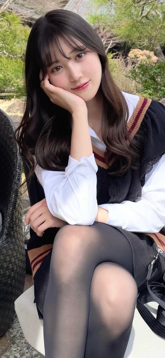 Woman in a school uniform and black tights posing outdoors