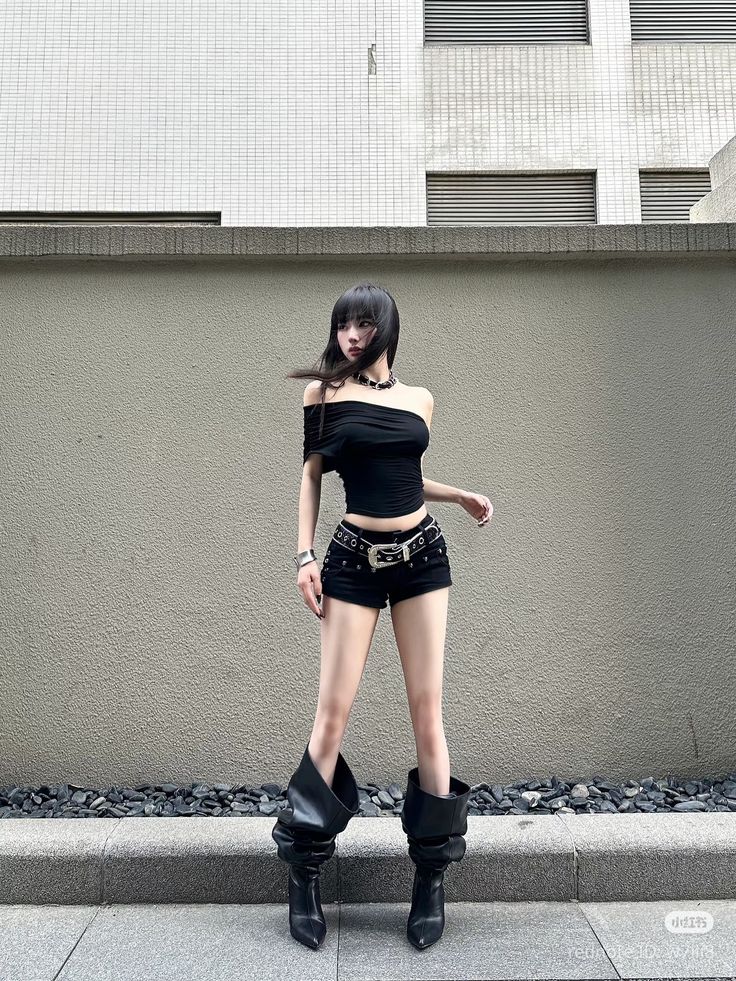 Woman with black hair wearing an off-shoulder top and shorts outdoors