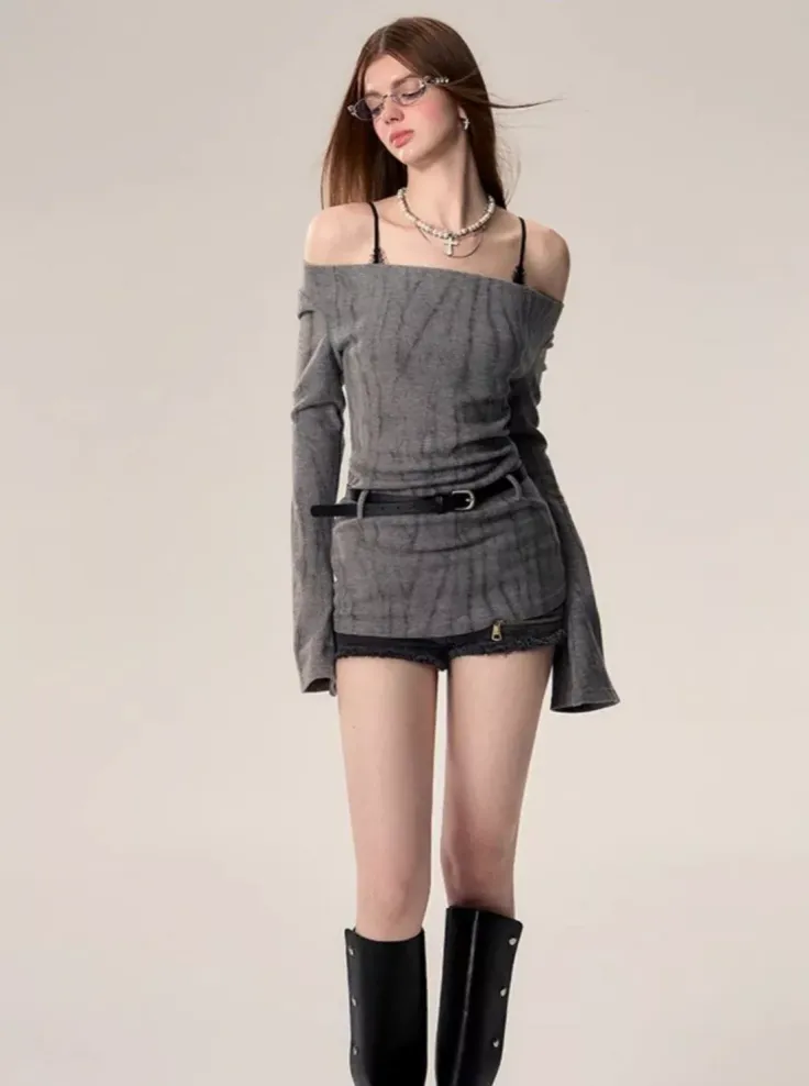 Woman with long hair wearing an off-shoulder top, shorts, and boots in a studio