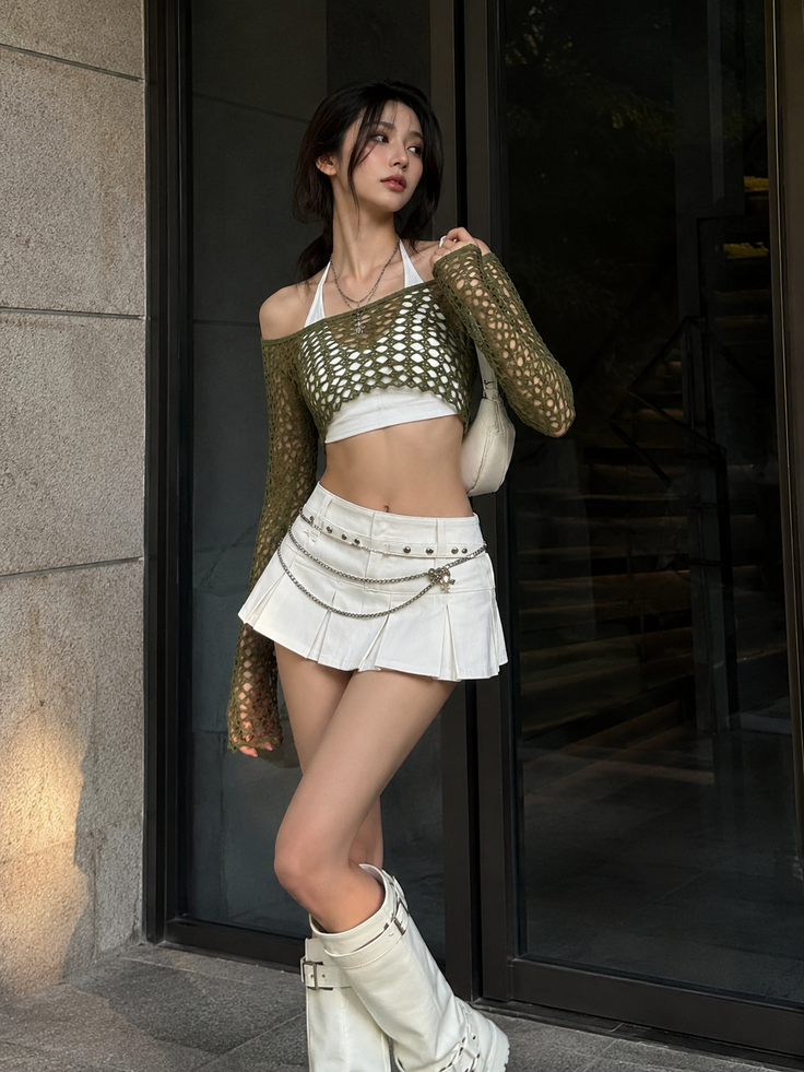 Woman in a white mini skirt and green mesh crop top with white boots