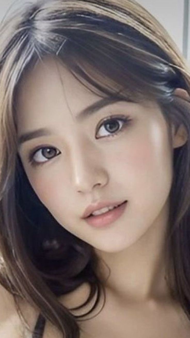 Woman with long brown hair and natural makeup looking at the camera