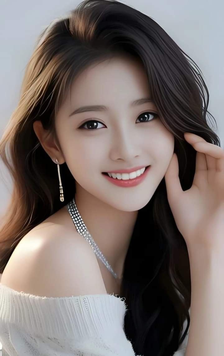 Smiling woman with long dark hair wearing an off-shoulder top and jewelry