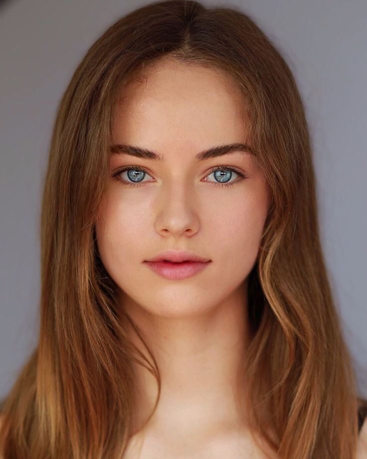 Young woman with long light brown hair and blue eyes in a portrait shot