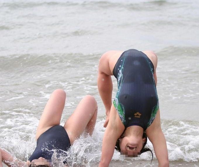 Two people in swimsuits playing in the ocean water