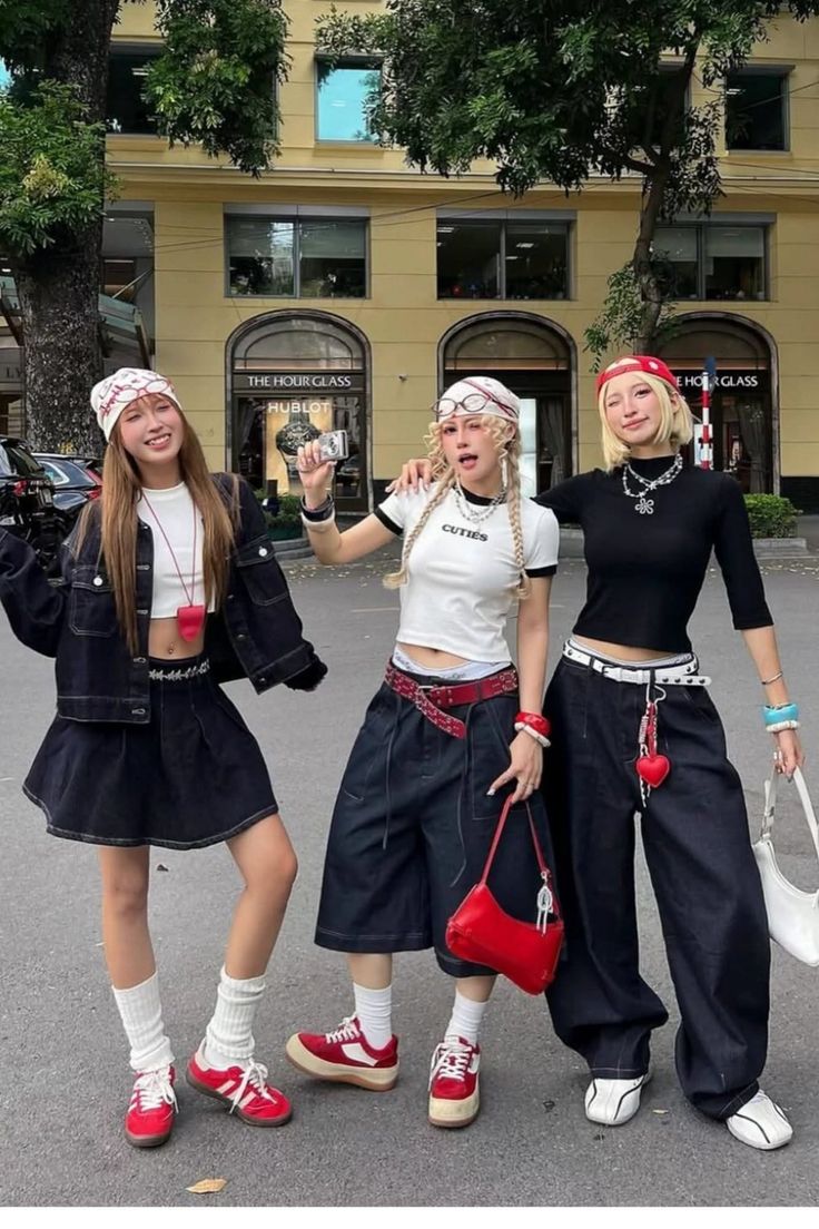 Three young women in street style outfits posing outdoors
