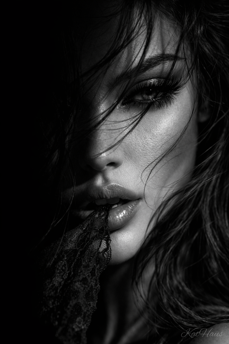 Close up black and white portrait of a woman with wet hair and lace in her mouth