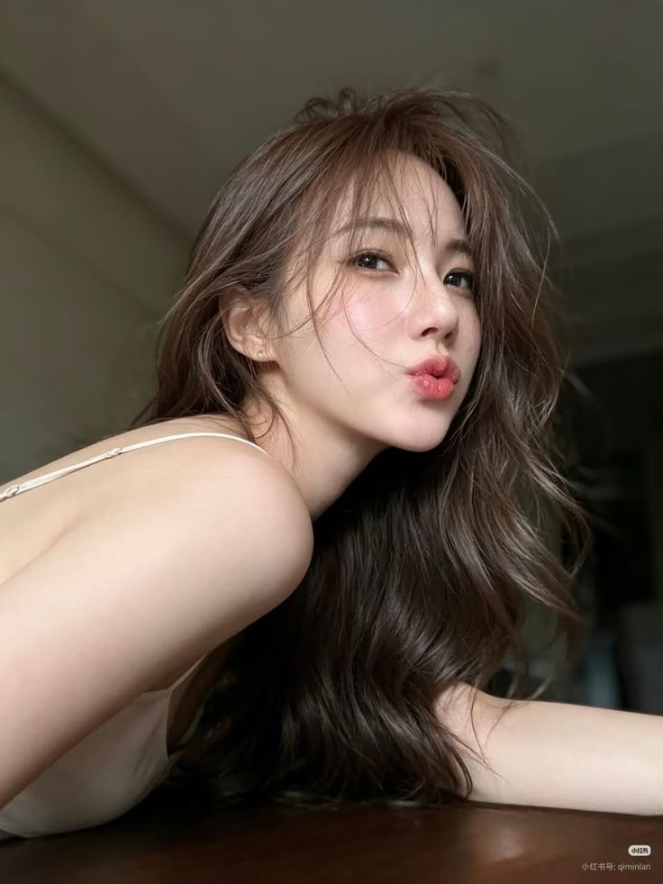 Woman with long hair and pouty lips in a suggestive pose