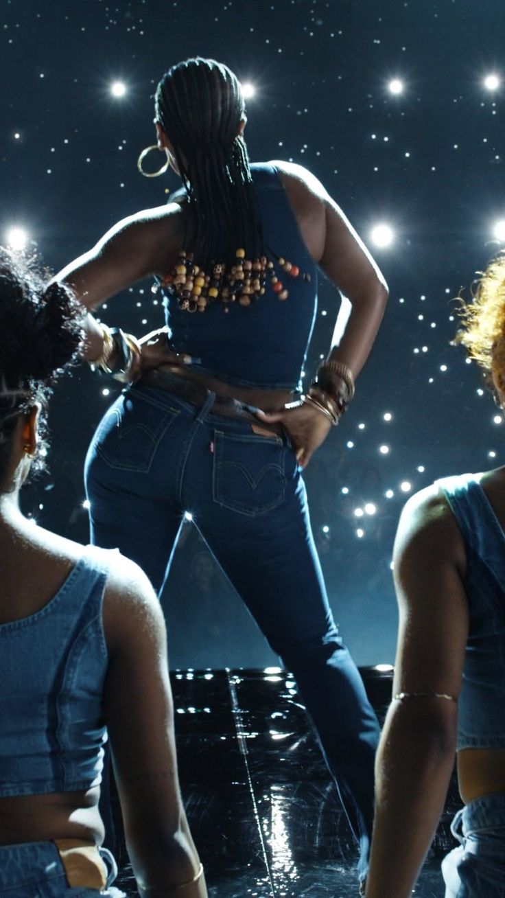 Woman with braided hair and denim jeans on a stage with bright lights