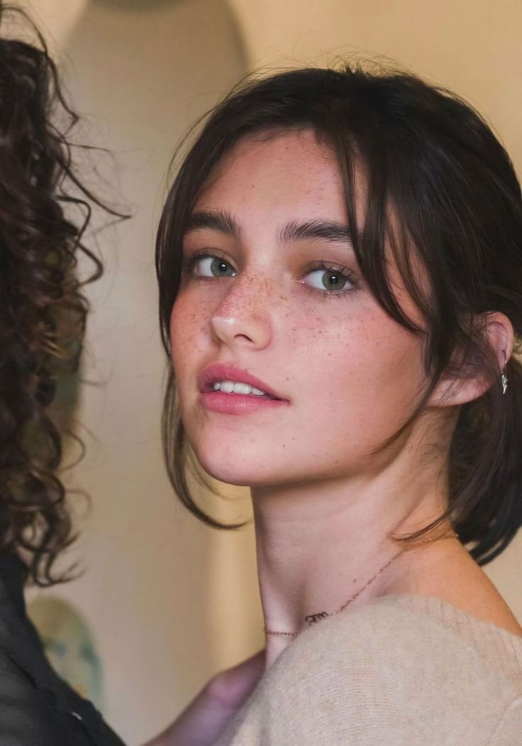 Woman with green eyes and freckles looking at the camera