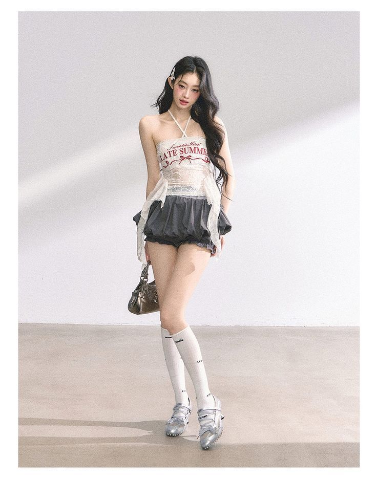 Woman with long dark hair wearing a halter top and ruffle shorts indoors