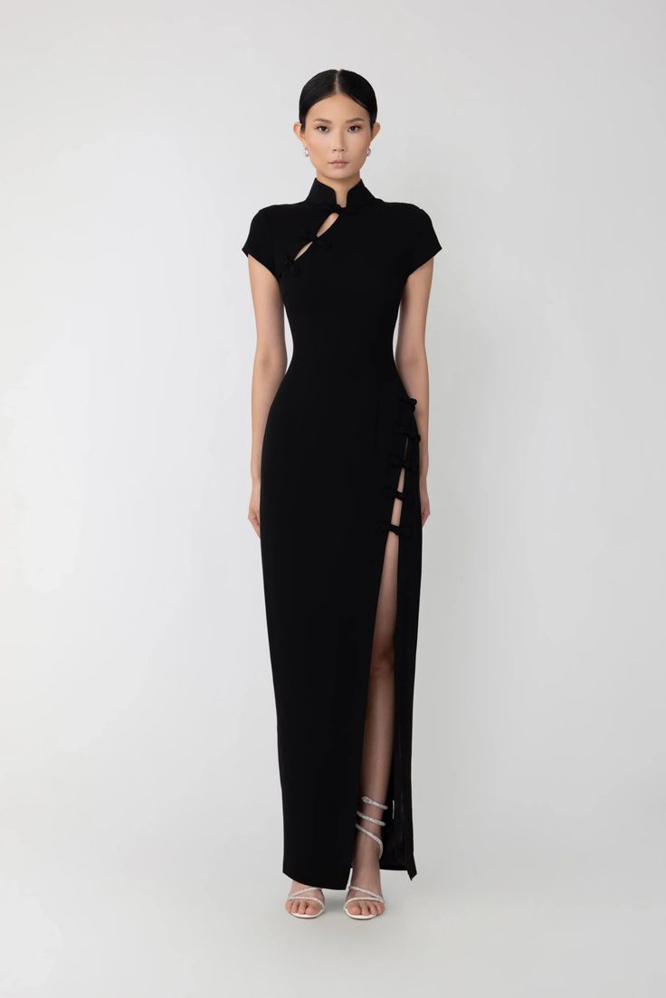 Woman in a black cheongsam-style dress with a high slit and high heels