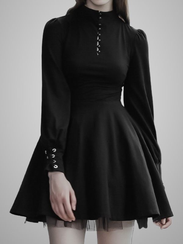 Woman in a black dress with a high collar and grommet details