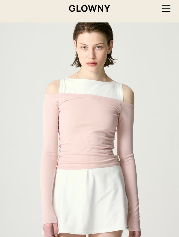 Woman with short hair wearing a pink off-shoulder top and white skirt
