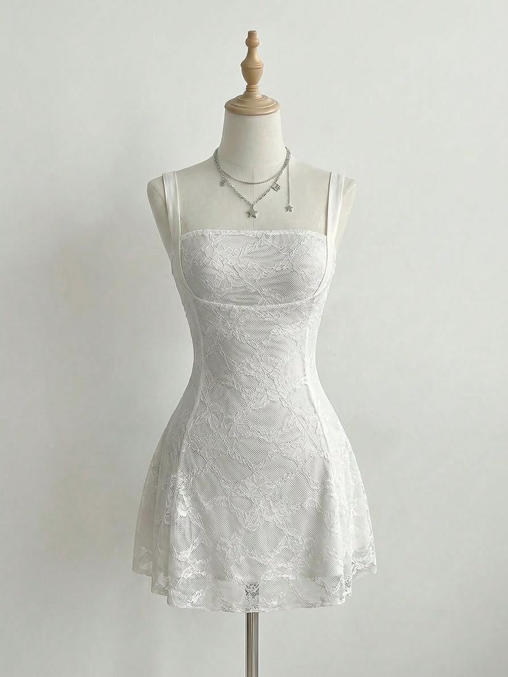 White lace dress on a mannequin with a silver star charm necklace