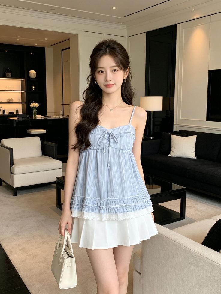Woman with long hair wearing a blue top and white skirt indoors