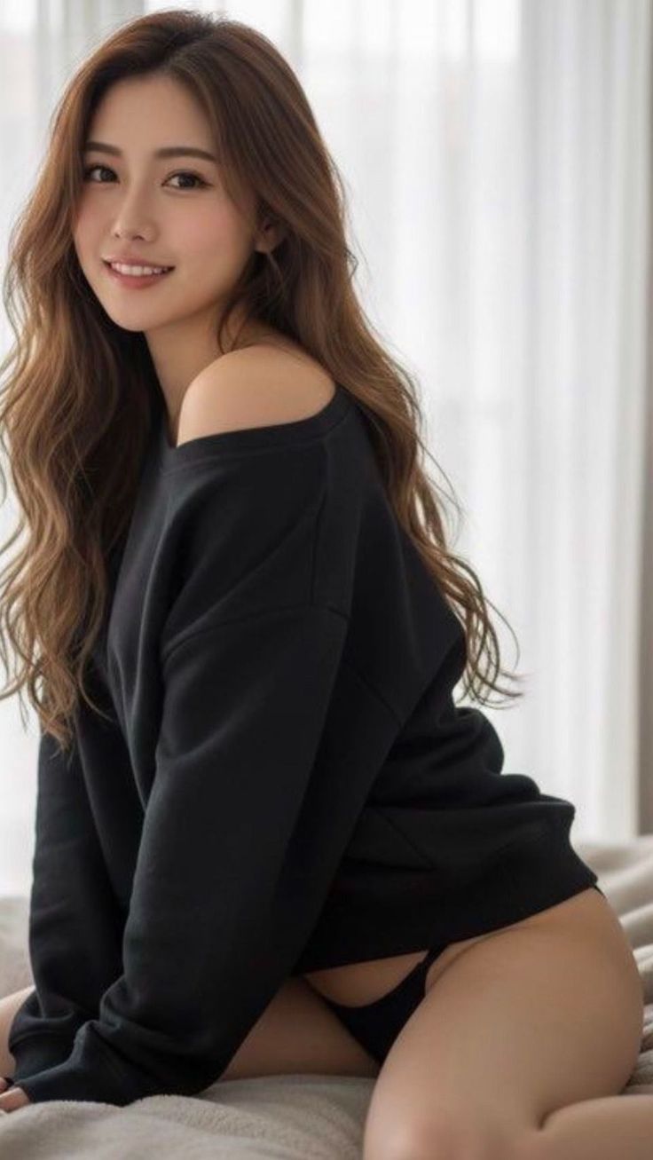 Woman with long hair wearing a black top and underwear in a provocative pose