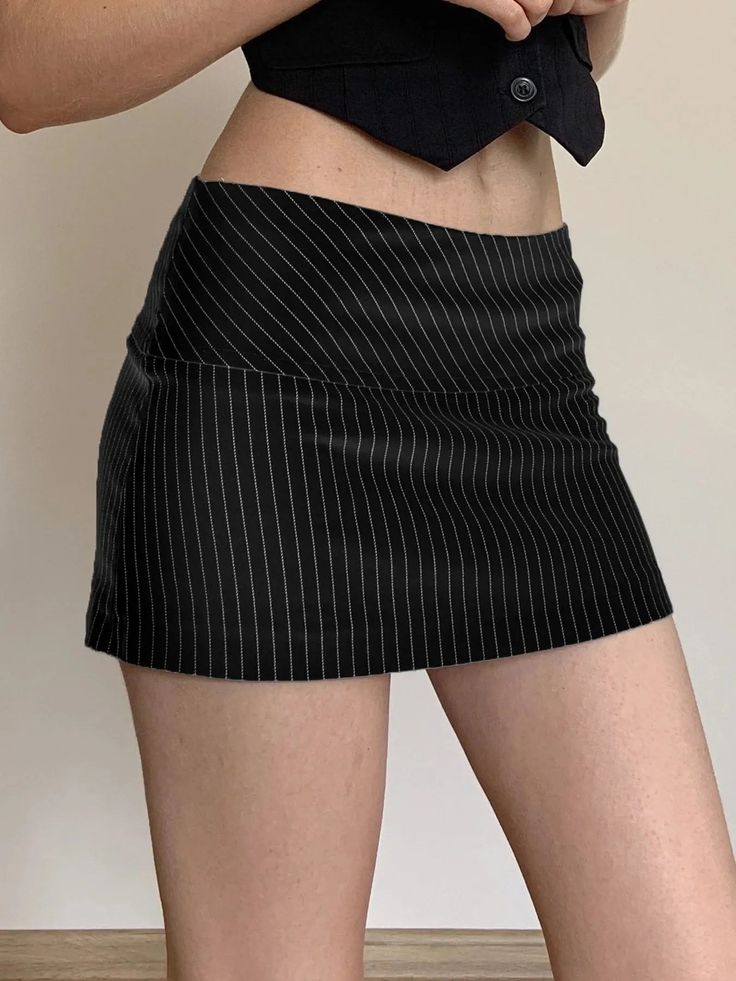 Person wearing a pinstripe mini skirt and a cropped top, showing exposed midriff