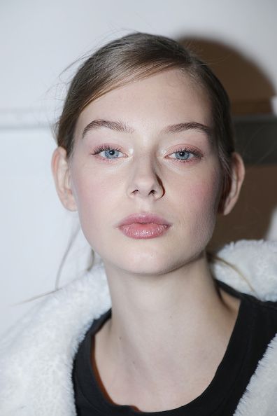 Woman with blue eyes and natural makeup wearing a white fluffy jacket