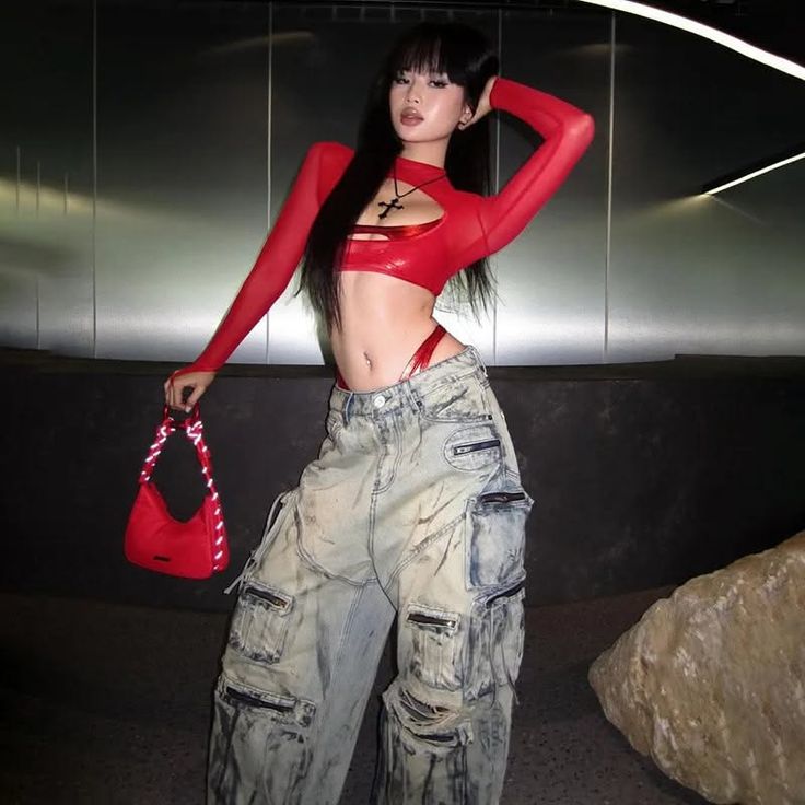 Woman in a red crop top and baggy jeans with a red thong visible