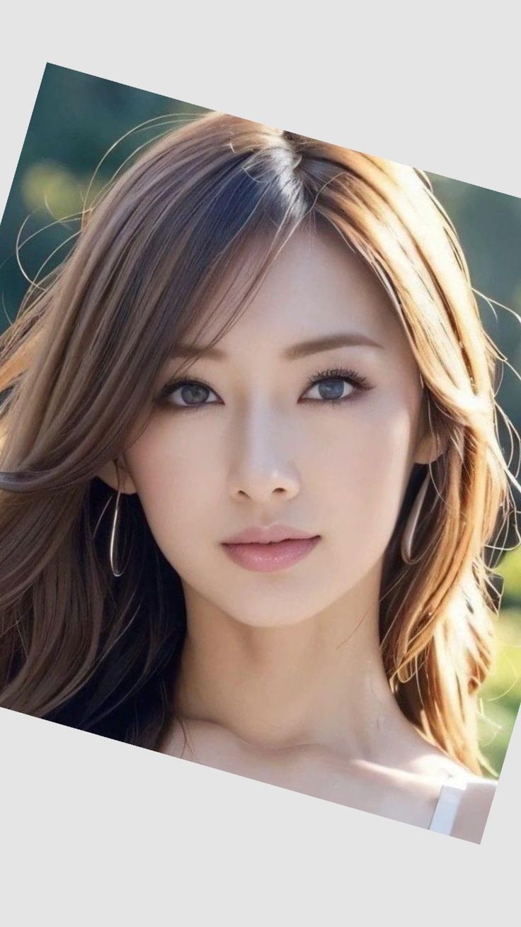 Woman with long brown hair and hoop earrings in an outdoor portrait