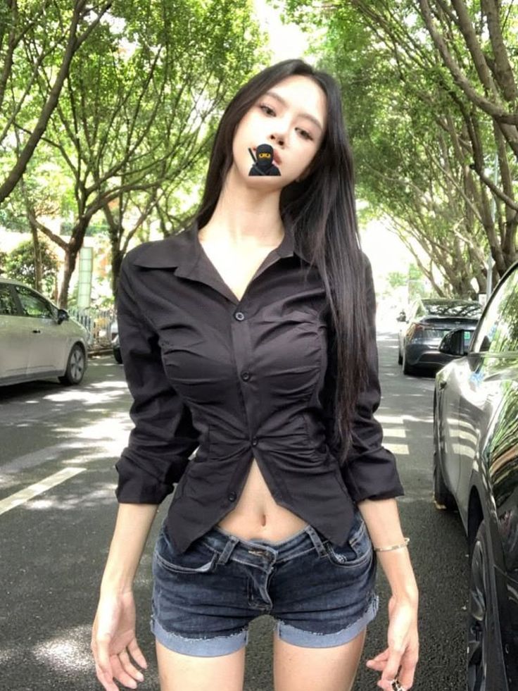 Woman in a black shirt and denim shorts on a street