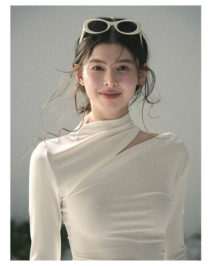 Woman with sunglasses on her head wearing a white top