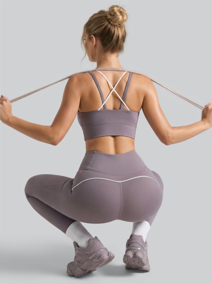 Woman in athletic wear squatting with her back to the camera