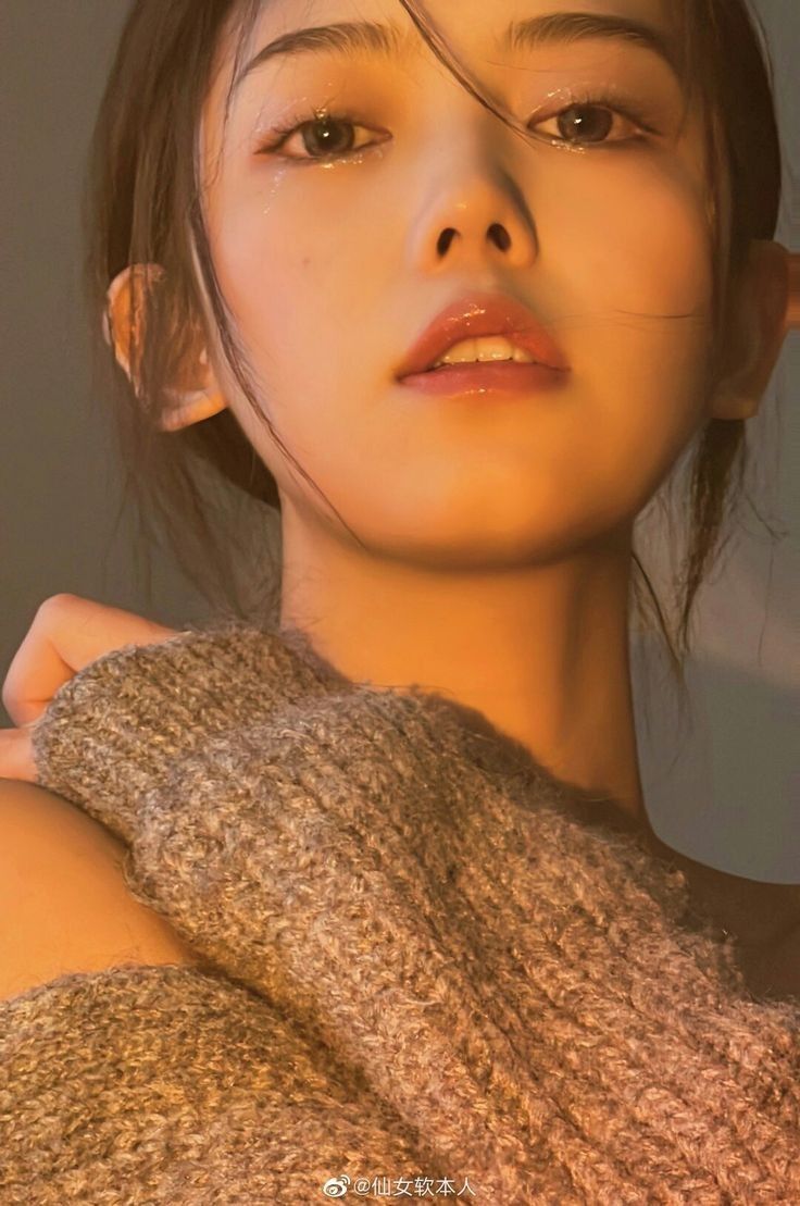 Close up portrait of a woman in a knitted sweater with warm lighting