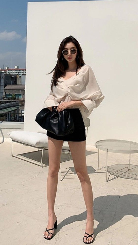 Woman in a blouse and mini skirt posing outdoors on a sunny day