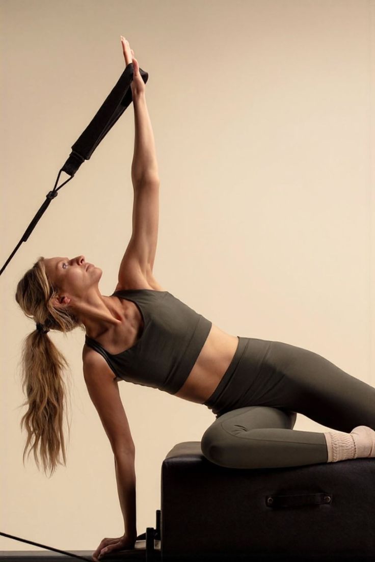 Woman in athletic wear doing pilates with a strap in a studio