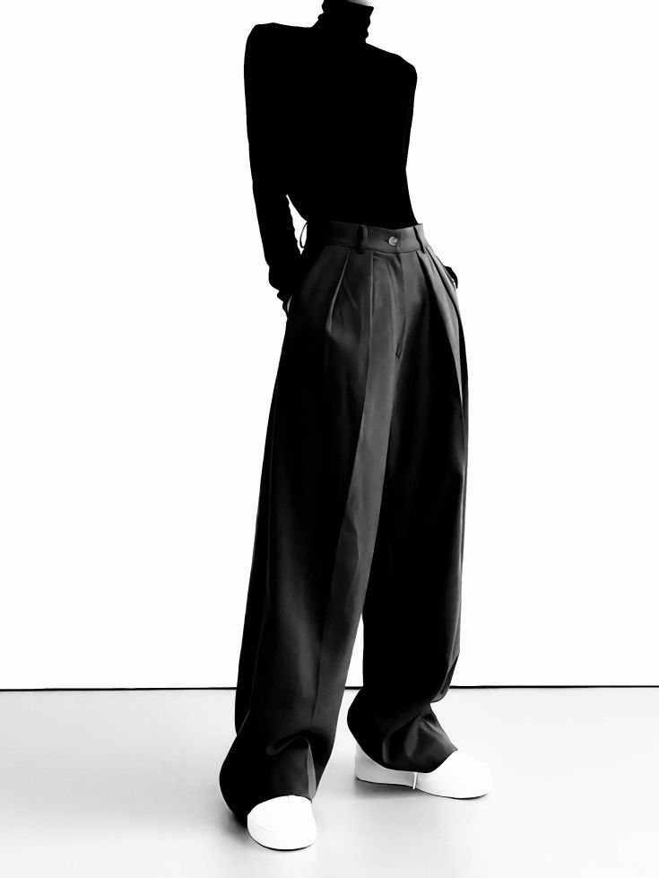 Person in a black turtleneck and wide leg pants with white sneakers