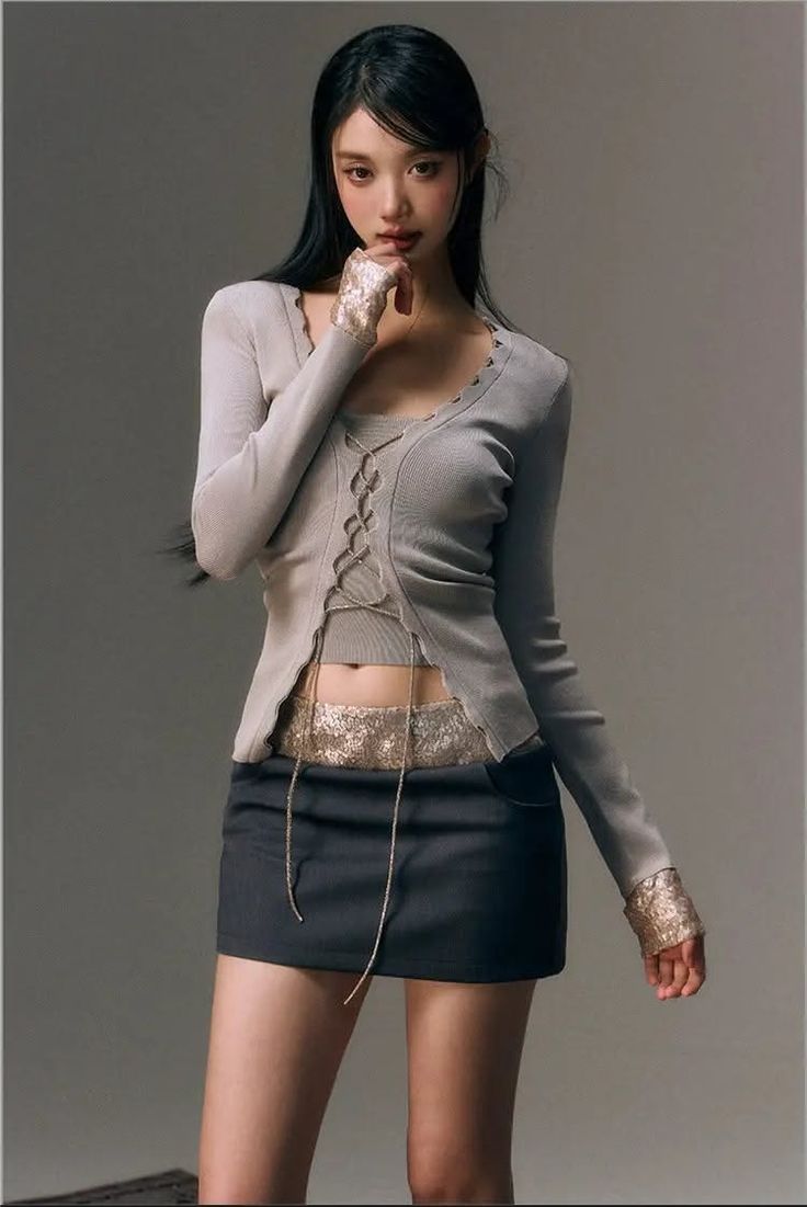 Woman in a mini skirt and cropped top posing in a studio
