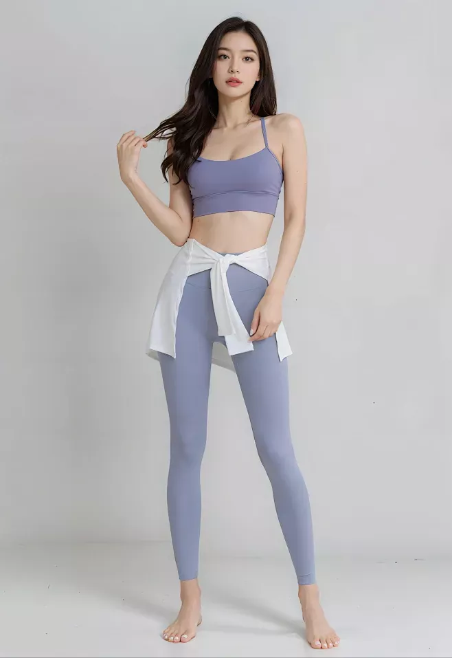 Woman in a purple sports bra and leggings with a white shirt tied around her waist