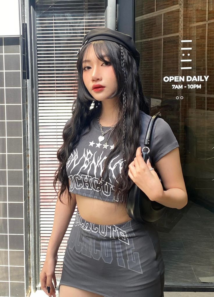 Woman with long dark hair wearing a crop top and mini skirt outdoors