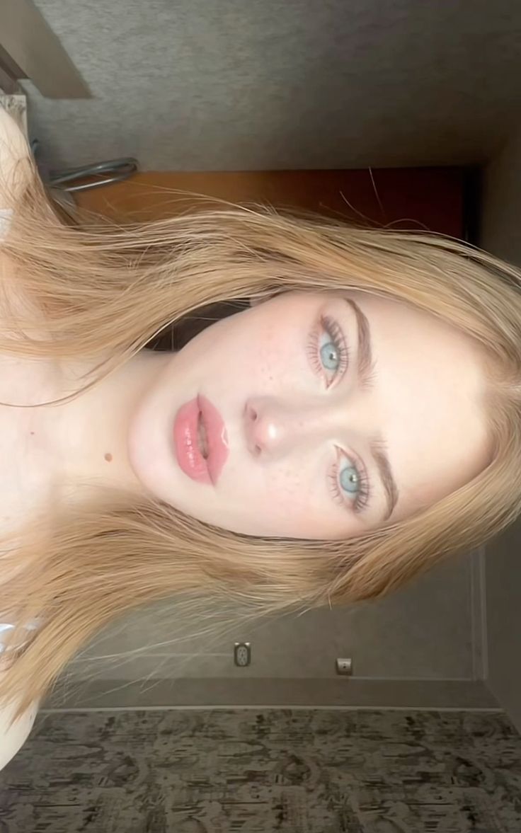 Close up portrait of a woman with long blonde hair and blue eyes