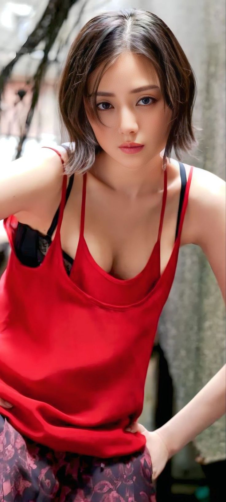 Woman with short hair wearing a red top and black bra, upper body portrait