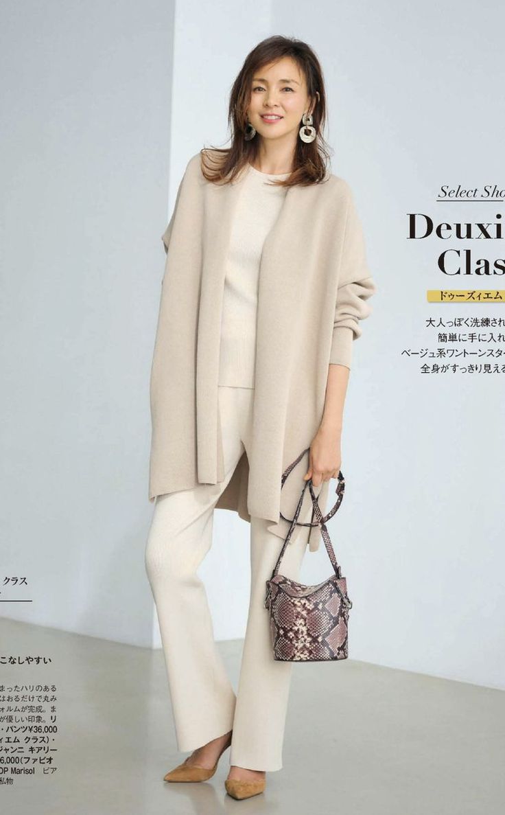 Woman in a neutral-toned outfit with a snakeskin bag and large earrings
