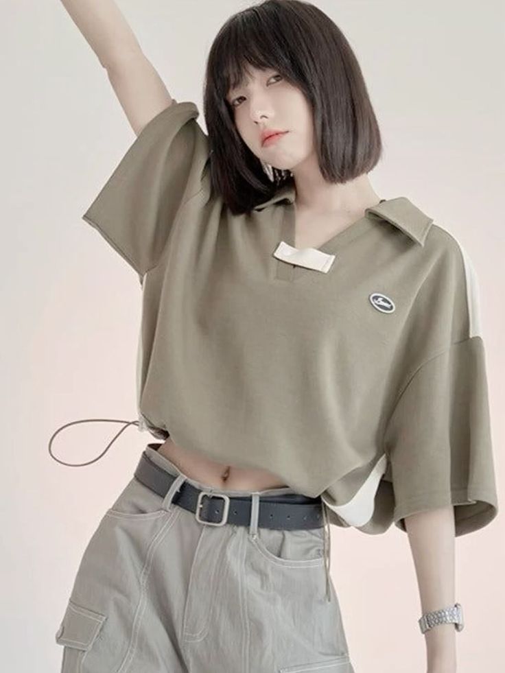 Woman with short hair wearing a crop top and cargo pants