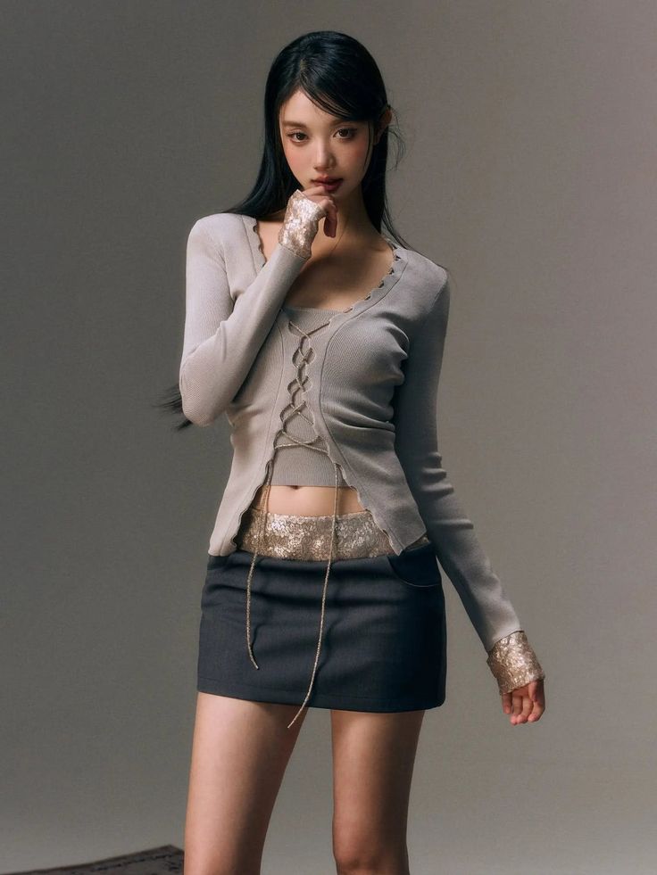 Woman in a cropped lace-up top and mini skirt with exposed midriff